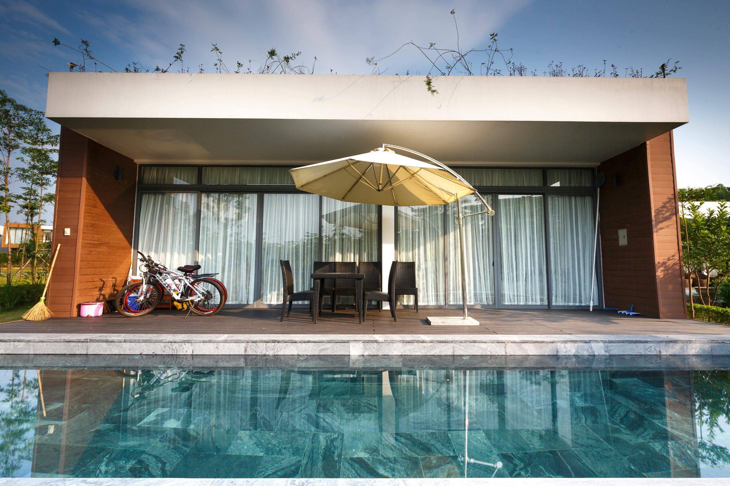 Contemporary outdoor patio with chairs and poolside view, perfect for luxury relaxation.